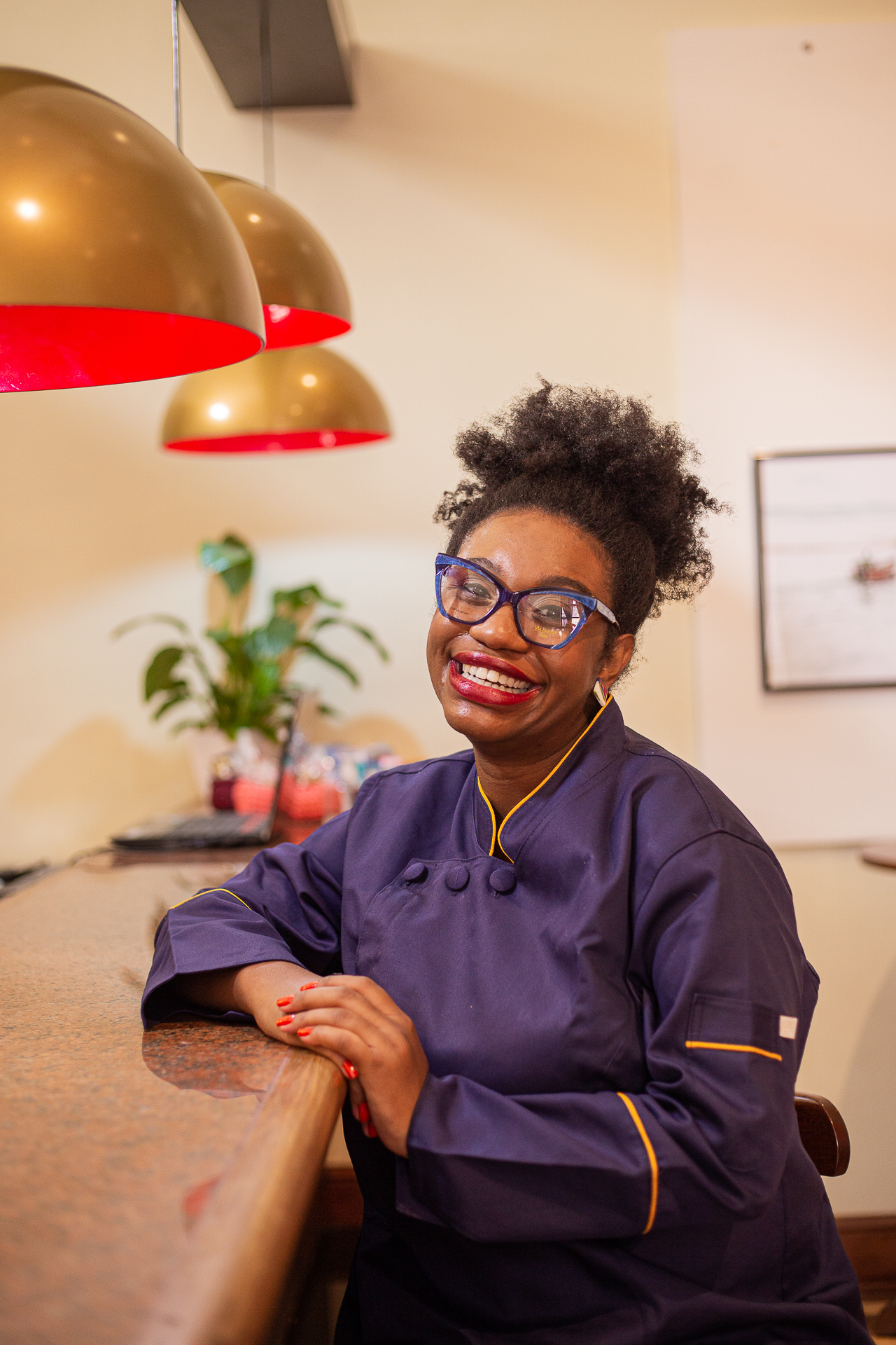 Bruna Crioula com jaleco de chef em cozinha